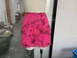 Vue détaillée d'une mini-jupe fuchsia avec une broderie complexe de paillettes florales