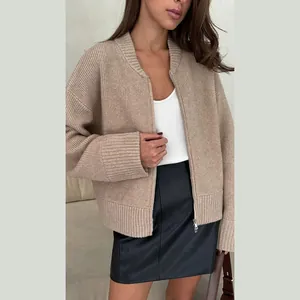 Detail view of beige ribbed knit cardigan with metallic zipper and long sleeves