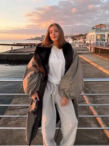 Elegant long khaki trench coat featuring a large black fur collar and stylish lantern sleeves
