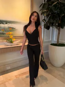 Schickes schwarzes, ärmelloses Strick-Crop-Top in Bandagen-Optik an einem Model