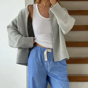 Detail view of grey zip-up knitted cardigan with ribbed cuffs and cozy fit