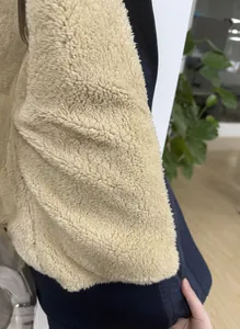 Detaillierte Nahaufnahme des dicken cremefarbenen Sherpa-Fleece-Futters an der blauen Jacke