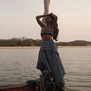 Zweiteiliges Urlaubsset mit gestreiftem Bandeau-Top und Rock auf einem Boot am Strand