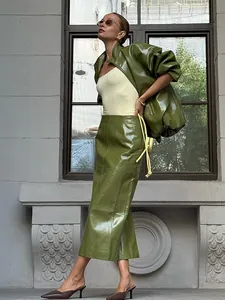 Schickes Model trägt eine amerikanische olivgrüne Vintage-Glanzlederjacke und ein Rockset