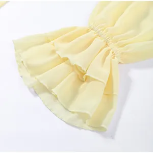 Close-up detail of the ruffled tiered bell sleeves on a light yellow chiffon top