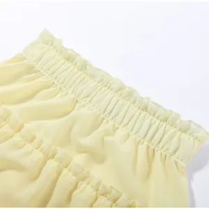 Close-up detail of yellow ruffled tiered skirt elastic waist and fabric texture