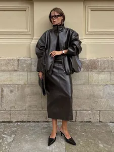Detailansicht des glänzenden Oversized-Lederjacken- und Maxirock-Sets im Retro-Look.