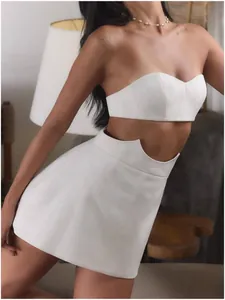 Elegant detail view of a white strapless bandeau top and matching cutout mini skirt