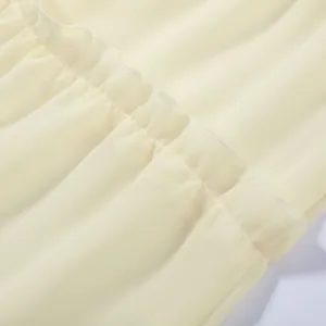 Detail of ruffled cream yellow chiffon fabric with neat stitching for vacation style clothing