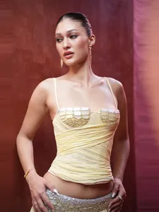 Détail de la taille pailletée et du bustier en maille plissée de l'ensemble
