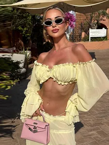 Two-piece yellow off-shoulder ruffled crop top and tiered maxi skirt resort set.