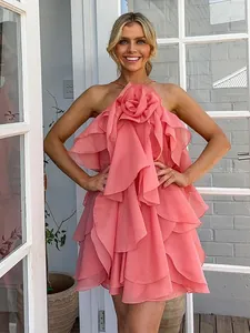 Chic coral pink halter neck mini dress featuring a large 3D fabric flower and layered ruffles