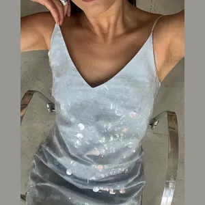 Close-up of light blue V-neck sequined mini dress with large shimmering discs
