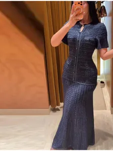 Close-up of elegant navy tweed long dress with shimmering sequin details