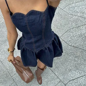 Detail view of a dark blue denim camisole dress with ruffled hem and scalloped neckline.