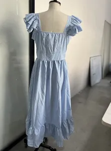 Vista posteriore di un vestito a righe bianche e blu con maniche a farfalla su manichino.