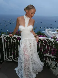 Modella indossa un elegante abito lungo in pizzo bianco con scollo all'americana e cut-out