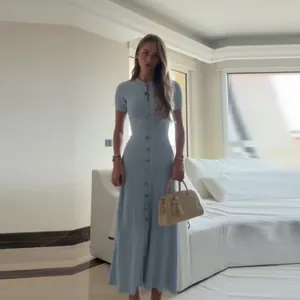 Elegant light blue slim fit knit maxi dress with sequin details and button down front.