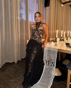 Elegante abito da sera nero in pizzo allacciato al collo con spacco in vita e gonna a balze