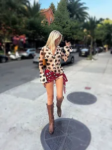 Stylish polka dot long sleeve shirt dress with red wrap skirt and brown leather boots
