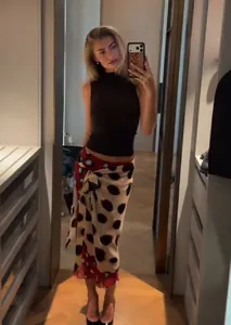 Full length mirror view showing the fit and drape of the polka dot wrap midi skirt