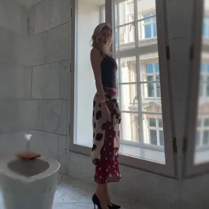 Detailed side view of high-waisted polka dot wrap skirt shown on model by a bright window