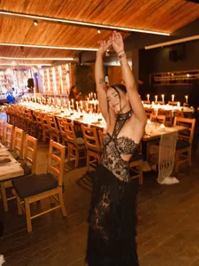 Sexy abito da sera nero in pizzo con tagli in vita in un ristorante a lume di candela