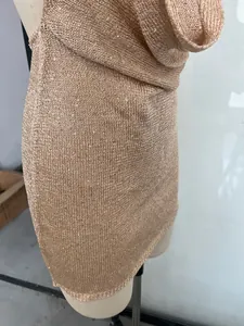 Detail view of a shimmering champagne halter cowl neck knit mini dress on a mannequin