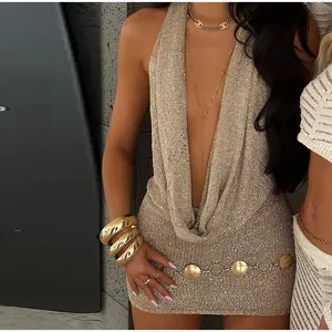 Close-up detail of a sexy shimmering gold knit mini dress featuring a halter cowl neck design