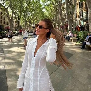 Detailed view of a white textured button-down mini dress featuring flared sleeves.