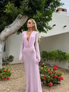Full-length view of elegant pink deep V-neck dress with split sleeves in outdoor garden
