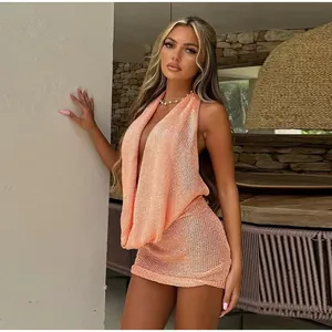 Close-up of orange halter knit mini dress featuring a draped cowl neckline and fine shimmer