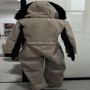Women's beige hooded one-piece ski jumpsuit with fur trim and arm fringe details