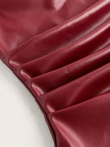 Primo piano del tessuto bordeaux in ecopelle plissettata per un top a fascia.