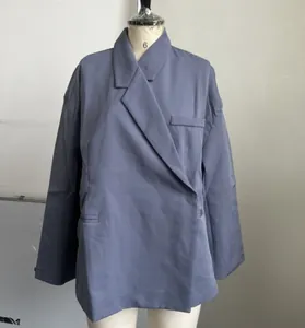 Vista detallada de una chaqueta blazer azul grisácea con diseño de dobladillo único.