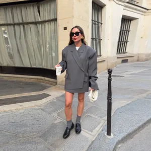 Vista detallada de estilo callejero de un blazer gris oversize con dobladillo único