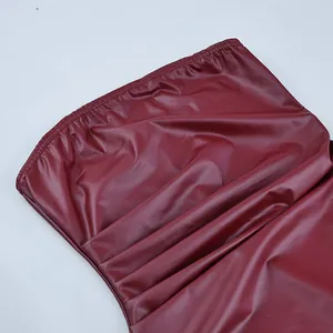Dettaglio di top a fascia in ecopelle bordeaux con bordo elasticizzato e arricciato