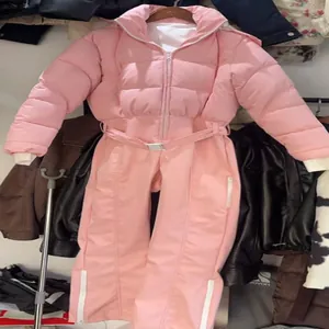 Detailed view of the stylish pink winter ski jumpsuit for women with a belted waist design.