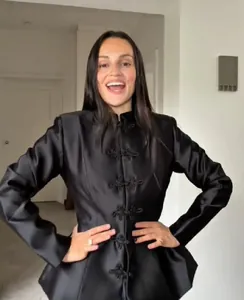 Veste élégante en satin noir avec boutons chinois et ourlet à basque évasé.