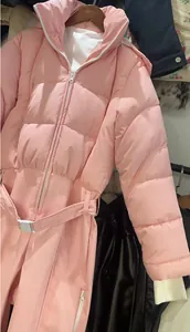 Detailed view of a fashionable pink one-piece ski suit for women with waist belt