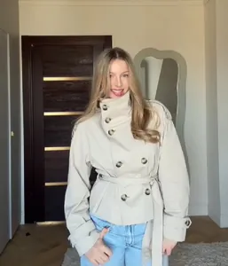 Full view of elegant beige short trench coat with stand-up collar and waist tie belt