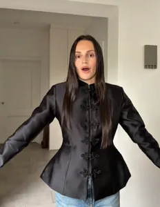 Détail de la veste noire en satin de style chinois avec boutons grenouilles traditionnels.