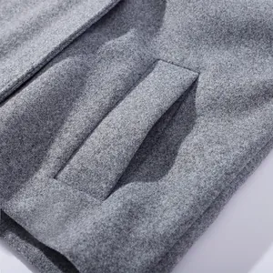 Detailed macro view of high-quality grey wool fabric and pocket on women's winter coat