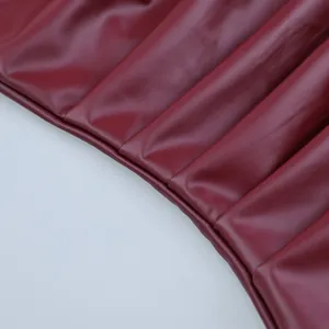 Primo piano del top a fascia in ecopelle bordeaux con texture plissettata e cuciture.