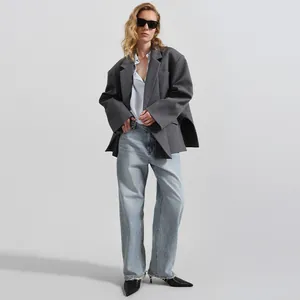 Vista detallada de un blazer gris oversize para mujer con dobladillo irregular