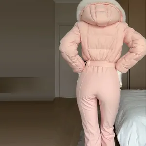 Detailed back view of a fashionable pink women's one-piece ski suit with white fur hood