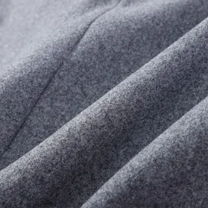 Detailed macro shot showing the premium soft texture of a grey woolen coat fabric