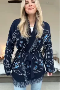 Detailed view of the navy blue paisley knit cardigan featuring a fringe hem and tie waist
