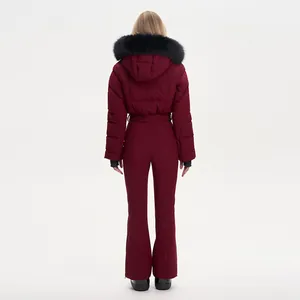 Back view of a burgundy women's one-piece ski jumpsuit with a black faux fur hood.