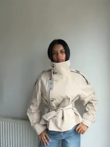 Elegant short beige trench coat with high stand collar and belted waist for women